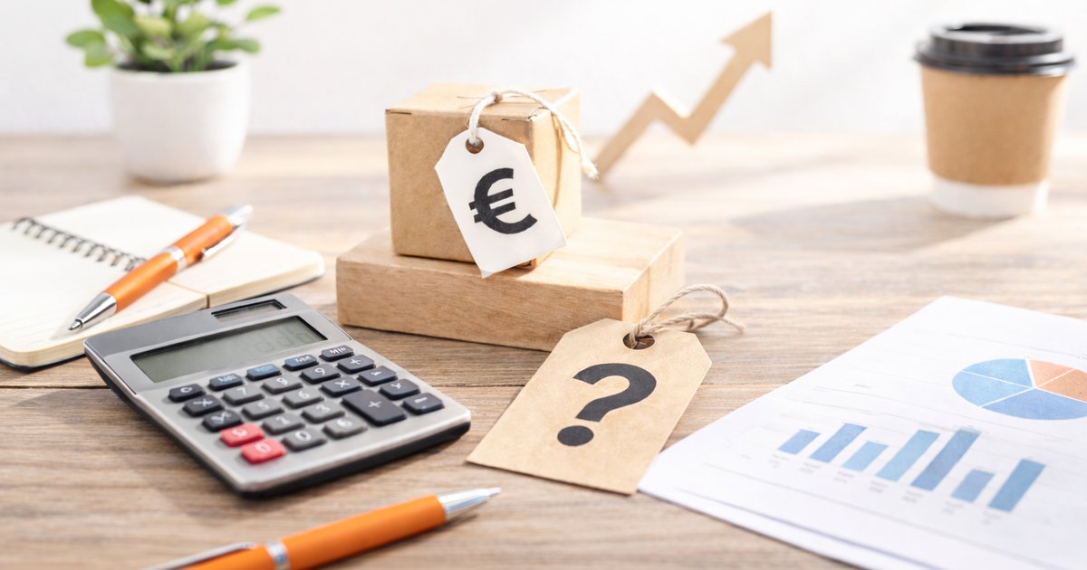 Càlcul del preu de serveis i productes amb calculadora i etiquetes sobre una taula de treball.